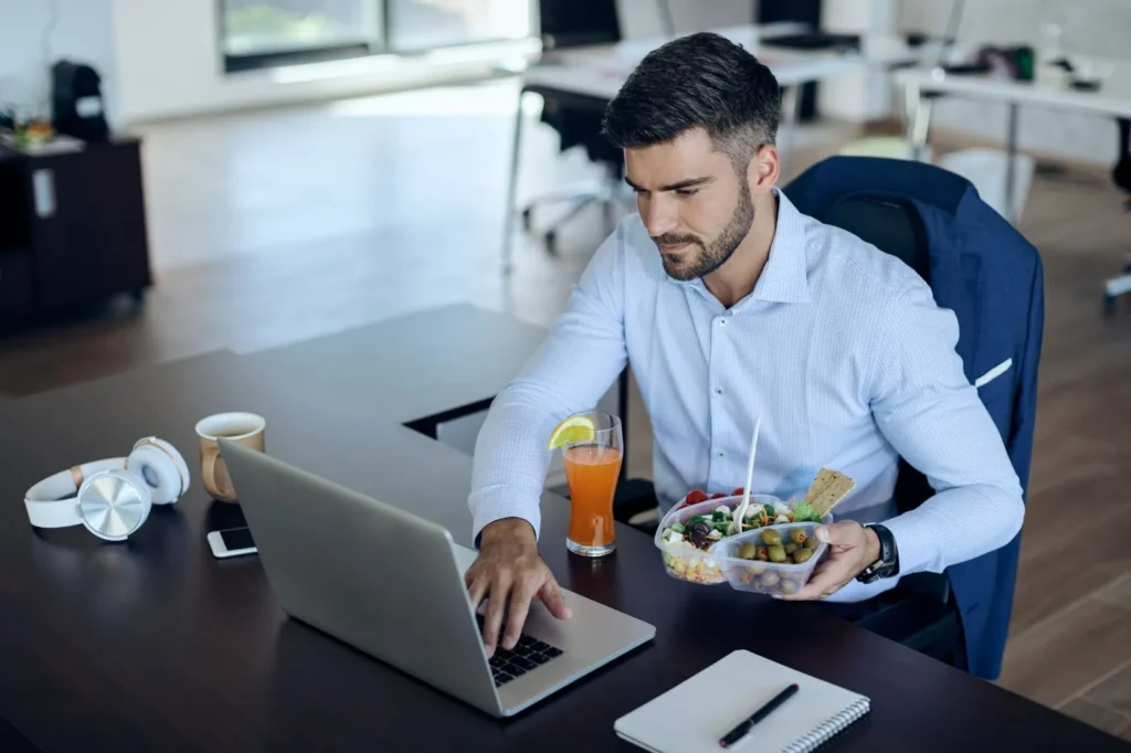 A worker sitting at a desk with a lunch