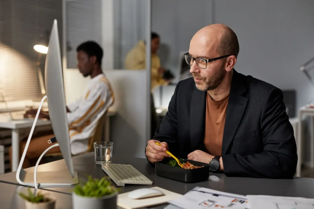 A man eating at his desk.